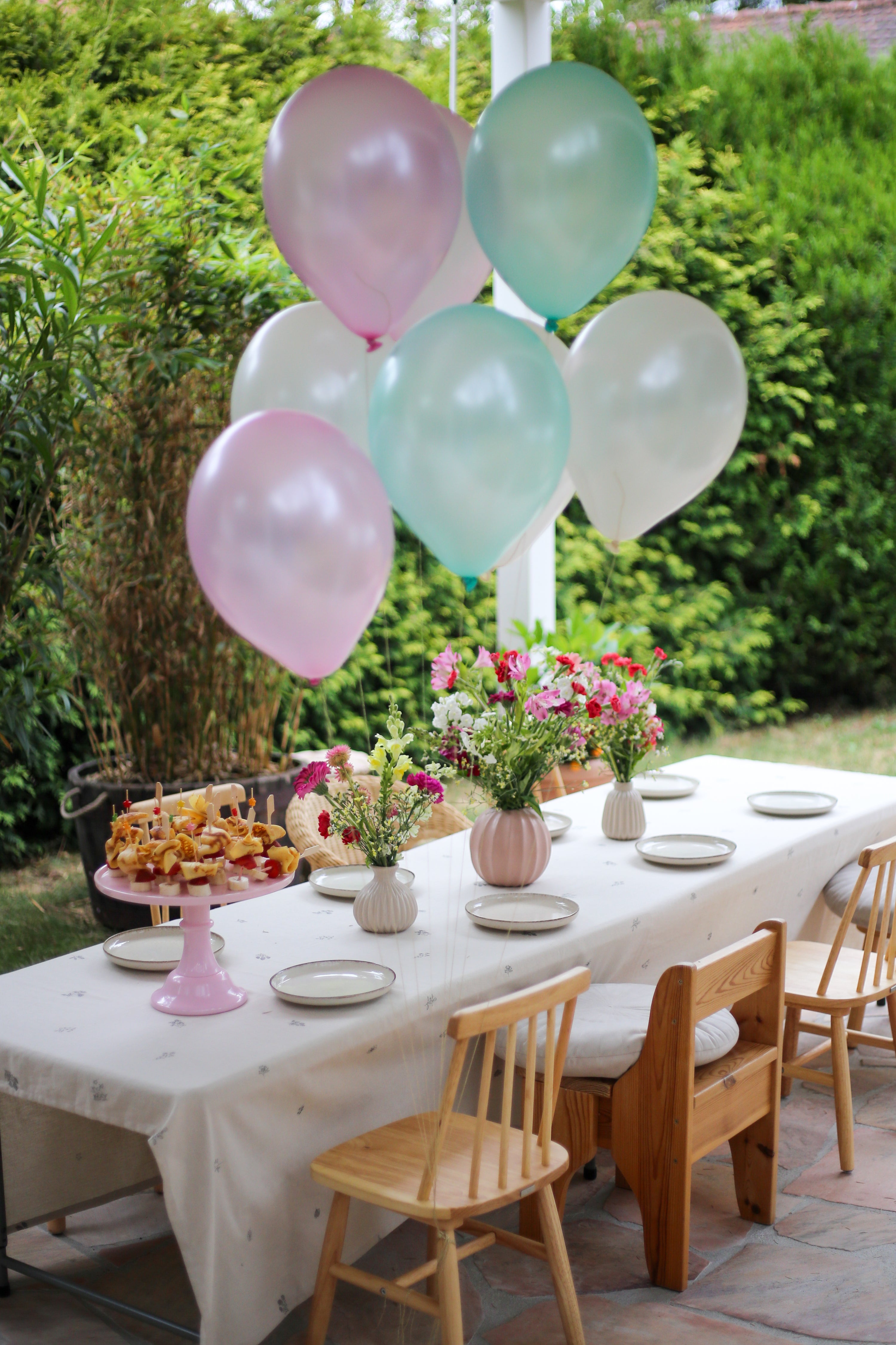 Ein mit Blumen und Häppchen gedeckter Tisch für einen Kindergeburtstag
