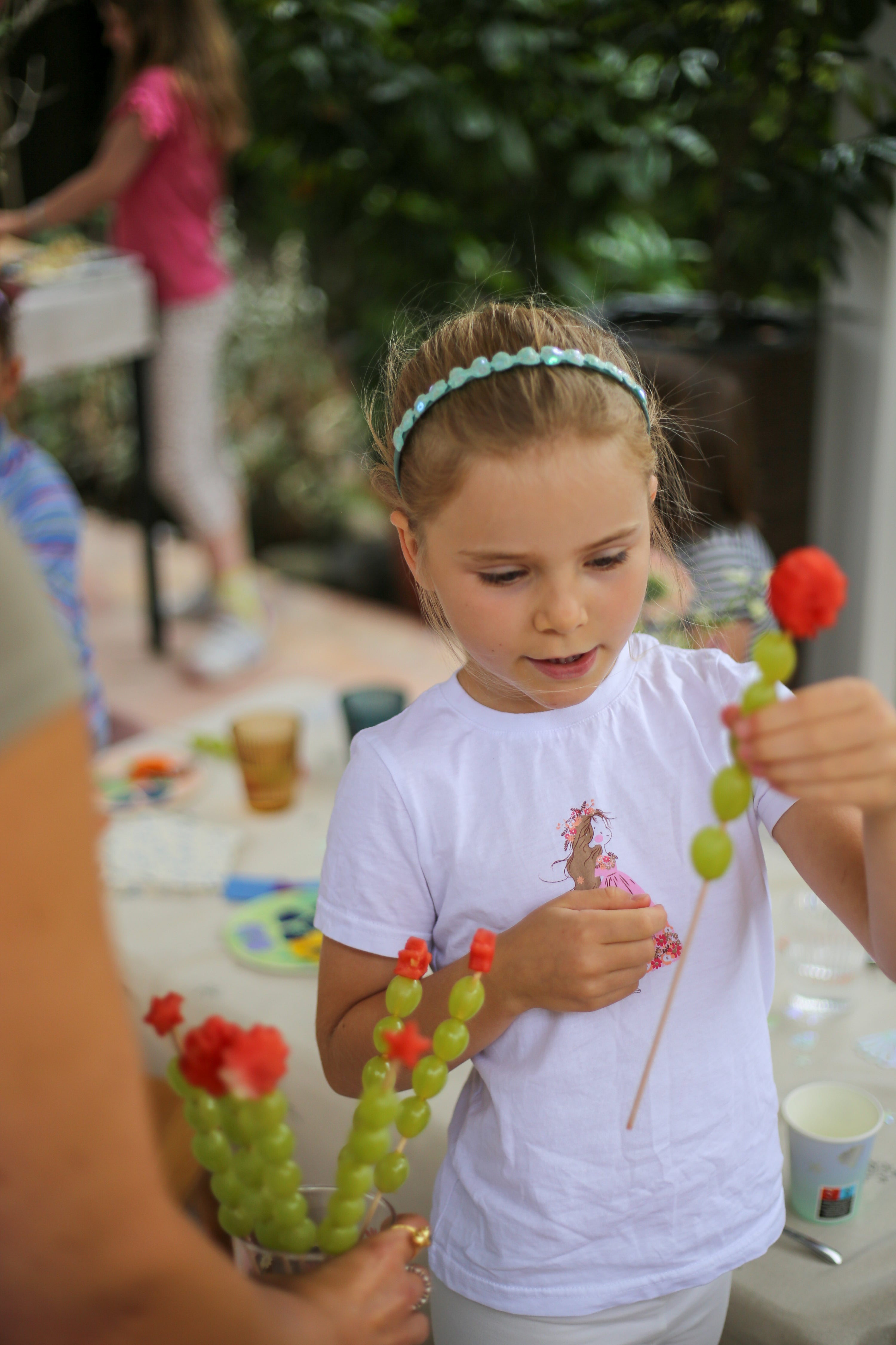 Mädchen mit gesunden Partysnacks auf einem Kindergeburtstag mit Premium Eventplanung